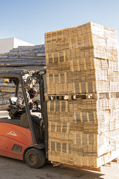 Torillo cargando palets de fondos de envases de madera para alimentos